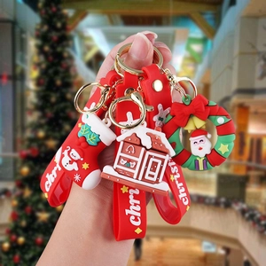 Detail of PVC Christmas keychains featuring gingerbread house and Santa wreath with red straps