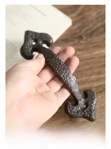 Macro view of vintage cast iron door handle with hammer-textured surface and petal base