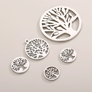 Polished silver stainless steel Tree of Life pendants in various sizes on beige background