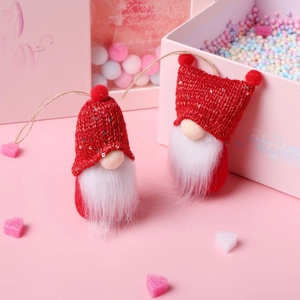 Detail of red knit Christmas gnomes with silver sequins and white beards on pink backdrop