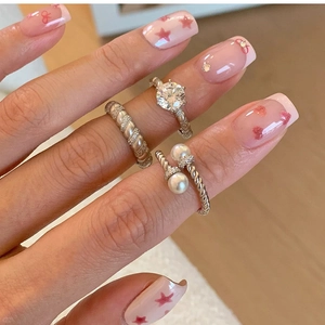 Detailed close-up of a stackable jewelry set with a solitaire diamond ring and pearls