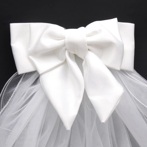 Detail view of a white satin wedding bow with lightweight mesh bridal veil accessories