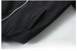 Detail of black bomber jacket featuring side pocket, silver zipper and elastic hemline