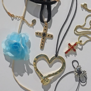 Gothic cross necklace set with heart pendants and blue fabric rose on white background