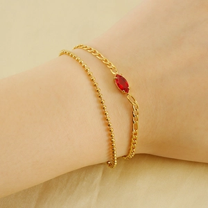 Double-layer gold beaded and Figaro chain bracelet with a red marquise zircon on wrist