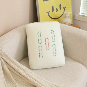 Close-up of Mahjong Five Strips plush pillow with soft sherpa texture on a sofa