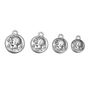 Detail of four vintage silver coin pendants with embossed figures in different sizes