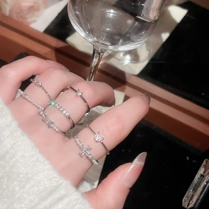 Close-up of stacked silver rings with pearls and zircon crystals on a hand