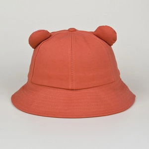 Close-up of brick red cotton bucket hat featuring 3D animal ears and textured stitching