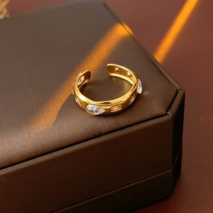 Detailed close-up of a gold water-drop zircon open ring on a vintage jewelry box