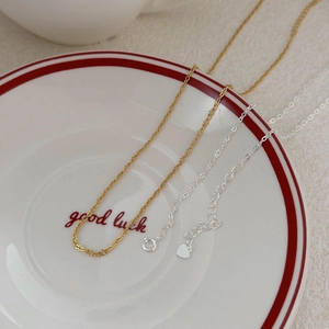 Minimalist 925 sterling silver chain necklaces in gold and silver on a ceramic tray