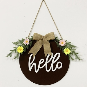 Detail of wooden door sign with hello text, burlap bow, and spring daisy flowers