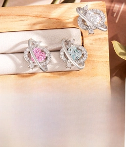 Dettaglio orecchini a cuore pianeta in argento con zirconi rosa e blu in scatola legno