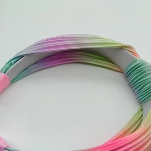 Dettaglio della fascia plissettata sfumata arcobaleno con texture in seta morbida