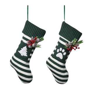 Pair of festive knitted pet Christmas stockings with green stripes and paw print designs