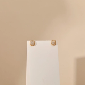 Detail of square gold plated stud earrings with pavé white cubic zirconia on white stand