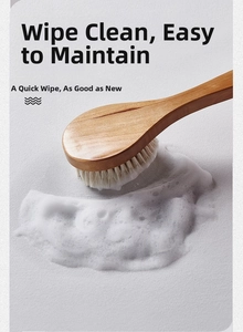 Close-up of a long wooden handle brush creating rich cleaning foam on marble texture mat