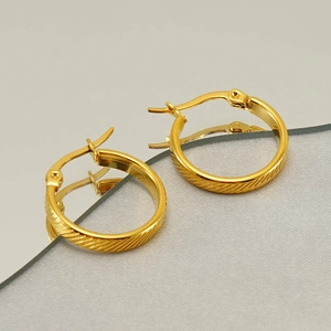 Elegant gold titanium hoop earrings with diagonal texture and secure hinged closure