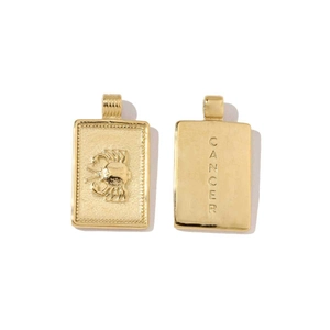 Macro detail of gold-plated Cancer zodiac pendant with crab relief and Cancer engraving