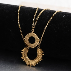 Close-up of double-layer 18K gold stainless steel necklace with sun and moon pendants