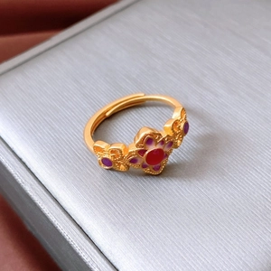 Macro detail of 24K gold plated ring featuring purple enamel flower and butterfly carving