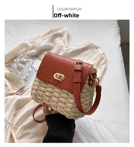 Detail of hand-woven straw crossbody bag with brown leather flap and golden twist lock