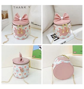 Detail view of girl's cylinder purse with heart prints, bow, and gold chain strap