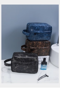 Three colors of premium PU leather travel toiletry bags stacked in a bathroom setting