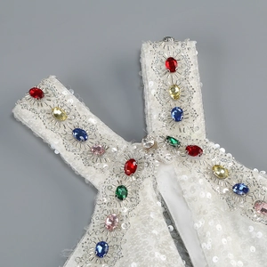 Detail of white sequin gown showing colorful rhinestones on halter neck straps