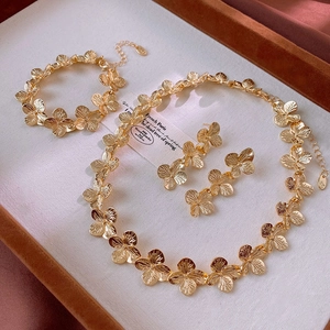 Detail view of vintage matte gold flower jewelry set with necklace and earrings on velvet