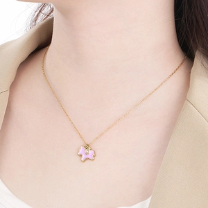 Golden unicorn titanium necklace with pink enamel flower pendant and diamond on a model