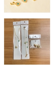 Detail of heart jewelry set with green gemstone and zircons in stainless steel