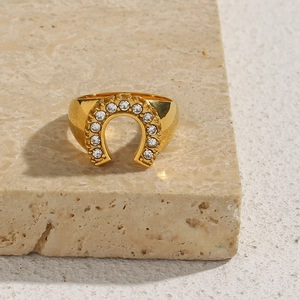 Detail of 18K gold U-shape horseshoe ring with sparkling zircons on stone base