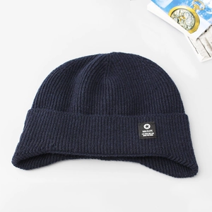 Macro shot of navy blue ribbed knit beanie with folded cuff and star logo patch