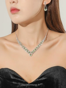 Détail du collier de mariée en V et des boucles d'oreilles avec strass verts