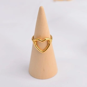 Bague cœur évidé en acier inoxydable plaqué or 18K sur un présentoir en bois élégant