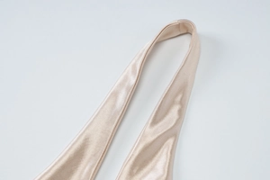 Détail de la robe en satin champagne montrant la bride du cou et la texture soyeuse