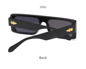 Detail of trendy black oversized square sunglasses with gold sword metallic temple accents