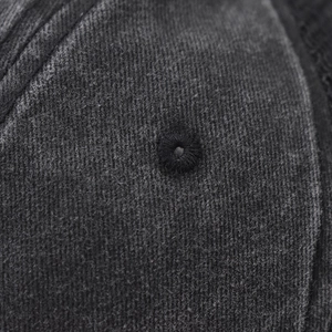 Detailed macro view of washed cotton fabric texture and embroidered eyelets on a baseball cap