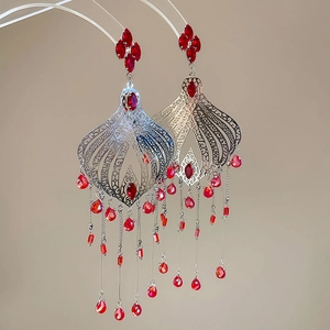Detail of vintage silver drop earrings featuring red crystals and long tassel chains