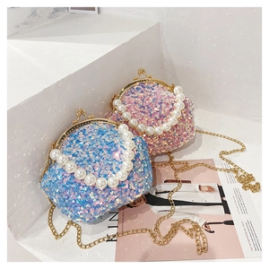 Detail of sequin shell bags in blue and pink with pearl handles and gold chains