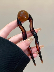 Détail d'épingle à cheveux en U vintage avec perle en résine ambre pour coiffure élégante