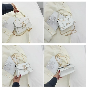 Detail of floral embroidery on white PU leather bag with pearl handle and chain