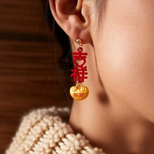 Close-up of New Year tassel earrings with lucky red and gold characters on model