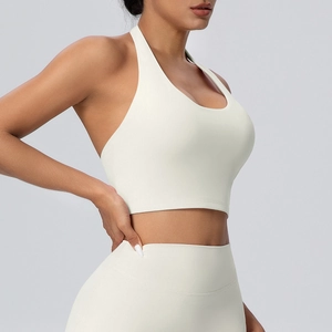 Dettaglio del reggiseno yoga allacciato al collo e legging a vita alta bianco crema