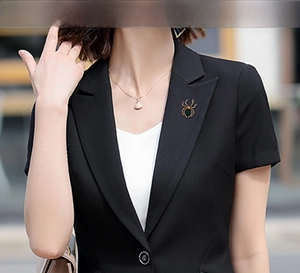 Close-up of vintage rhinestone spider brooch pinned on a black blazer lapel for styling