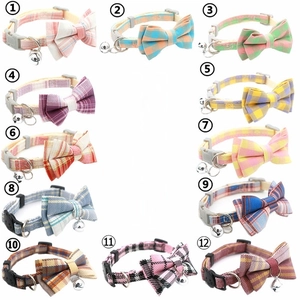 Detail view of twelve British style plaid pet collars with bows and small silver bells