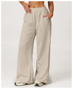Detail of high-waisted beige wide-leg sweatpants with side pockets and soft cotton texture