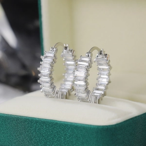 Macro detail of silver hoop earrings featuring channel-set rectangular AAA cubic zirconia