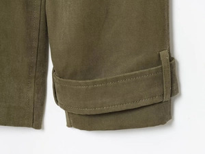 Detailansicht der armeegrünen Trenchcoat-Manschetten mit verstellbaren Riemen und Nähten